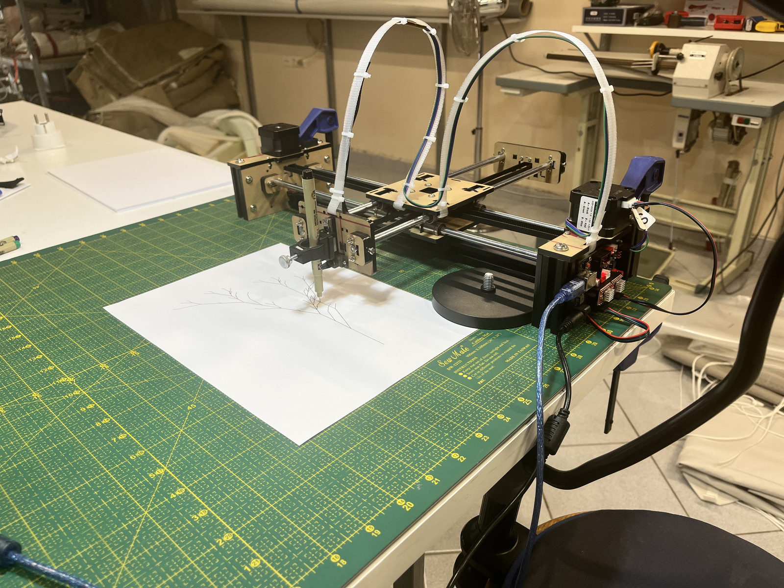 Drawdroid pen plotter drawing a botanical ink line on paper in the workshop